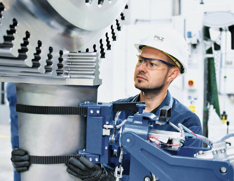 戴着安全帽和护目镜的人在检查机器