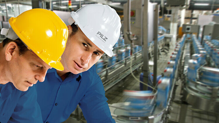 两名戴安全帽的男子站在机器前